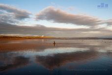 An exceptional morning on Lossiemouth West Beach, Covesea Lighthouse has just succumbed to the first light of the day. The tide is full out offering a glass surface reflection.